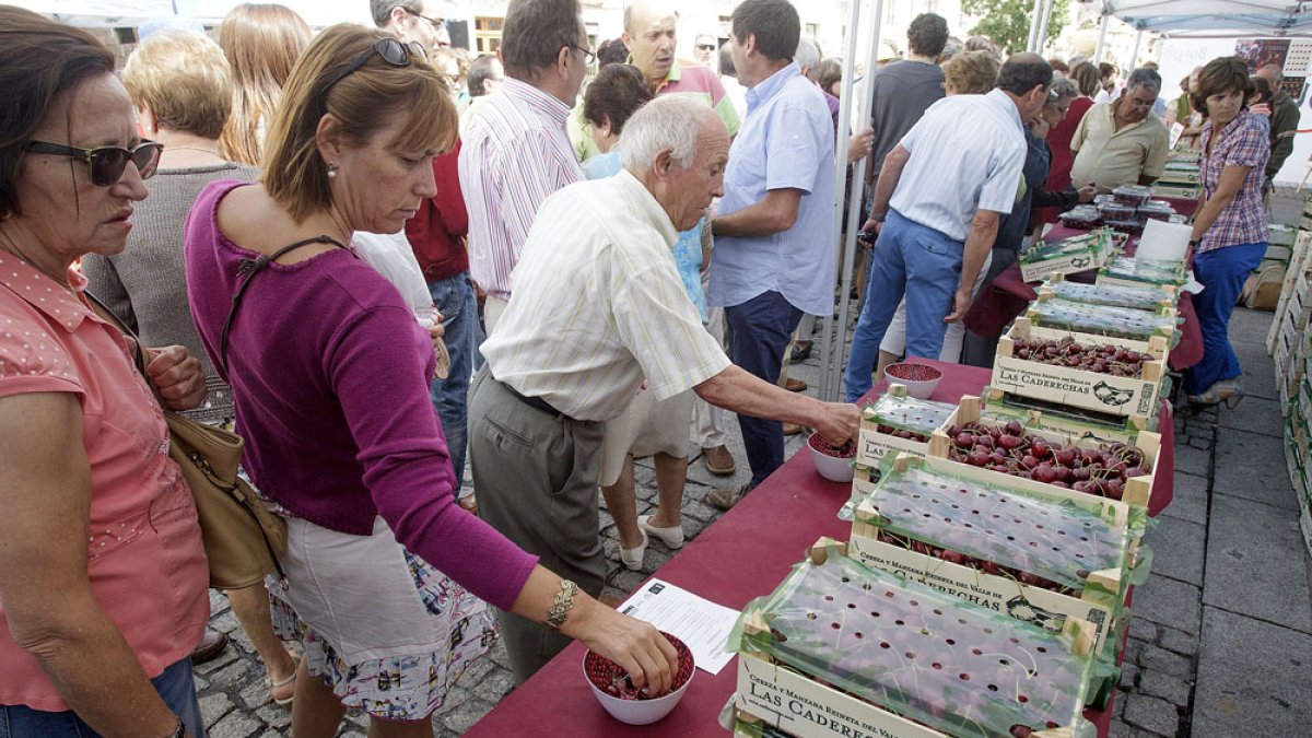 Varias personas degustan las cerezas en uno de los puestos en una edición anterior de la feria. ECB