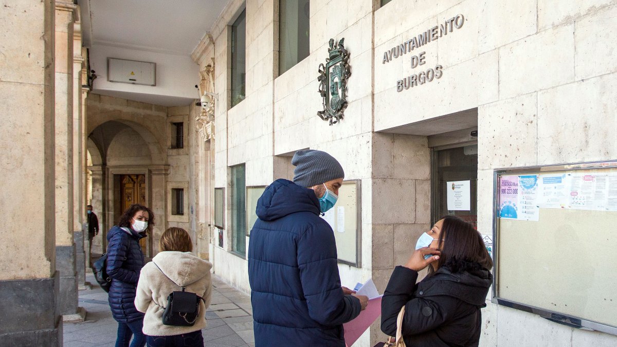 Varias personas esperan a la puerta del Ayuntamiento de Burgos para realizar gestiones. TOMÁS ALONSO
