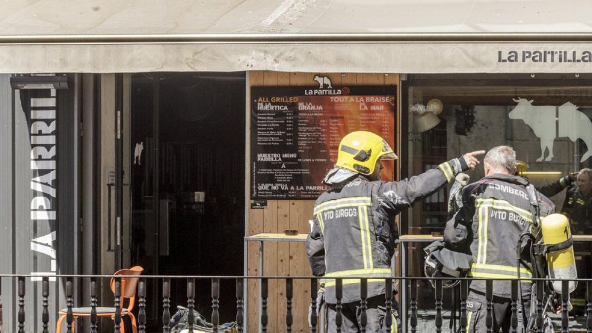 Dos bomberos frente a la entrada del restaurante.-SANTI OTERO