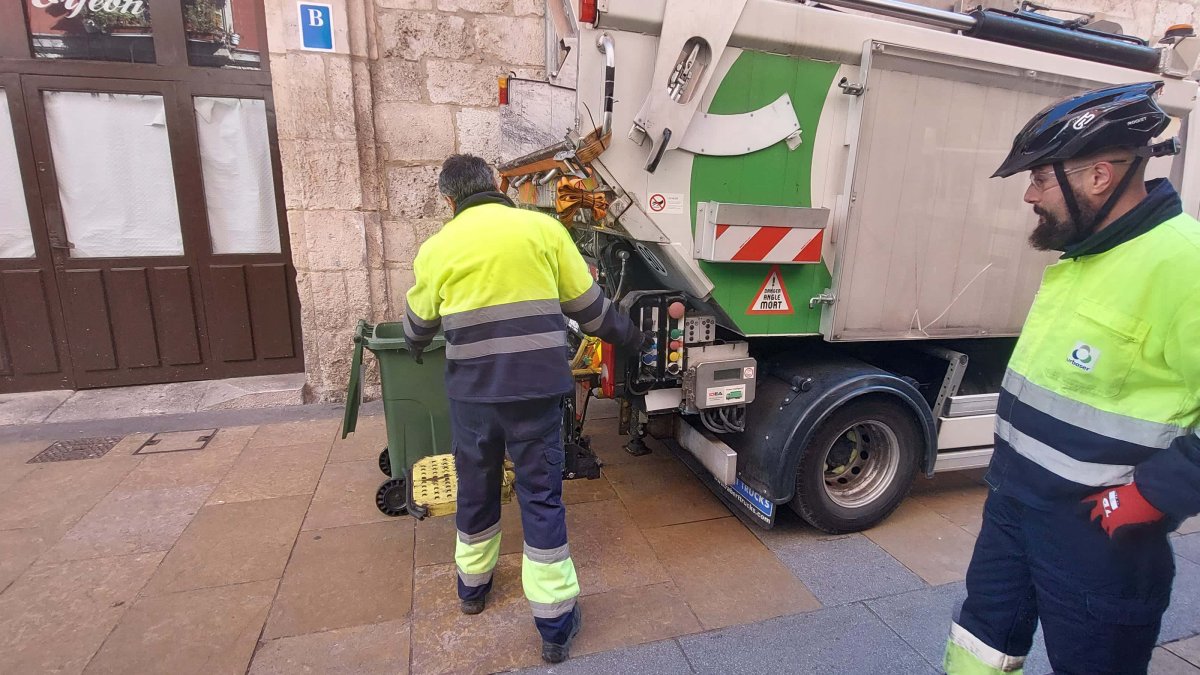 Dos trabajadores en la recogida de basuras puerta a puerta en el centro de Burgos. L. G. L.