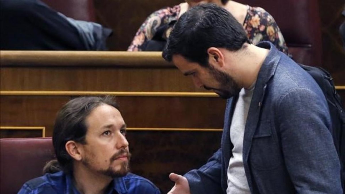 Pablo Iglesias y Alberto Garzón conversan en el hemiciclo del Congreso.-EFE