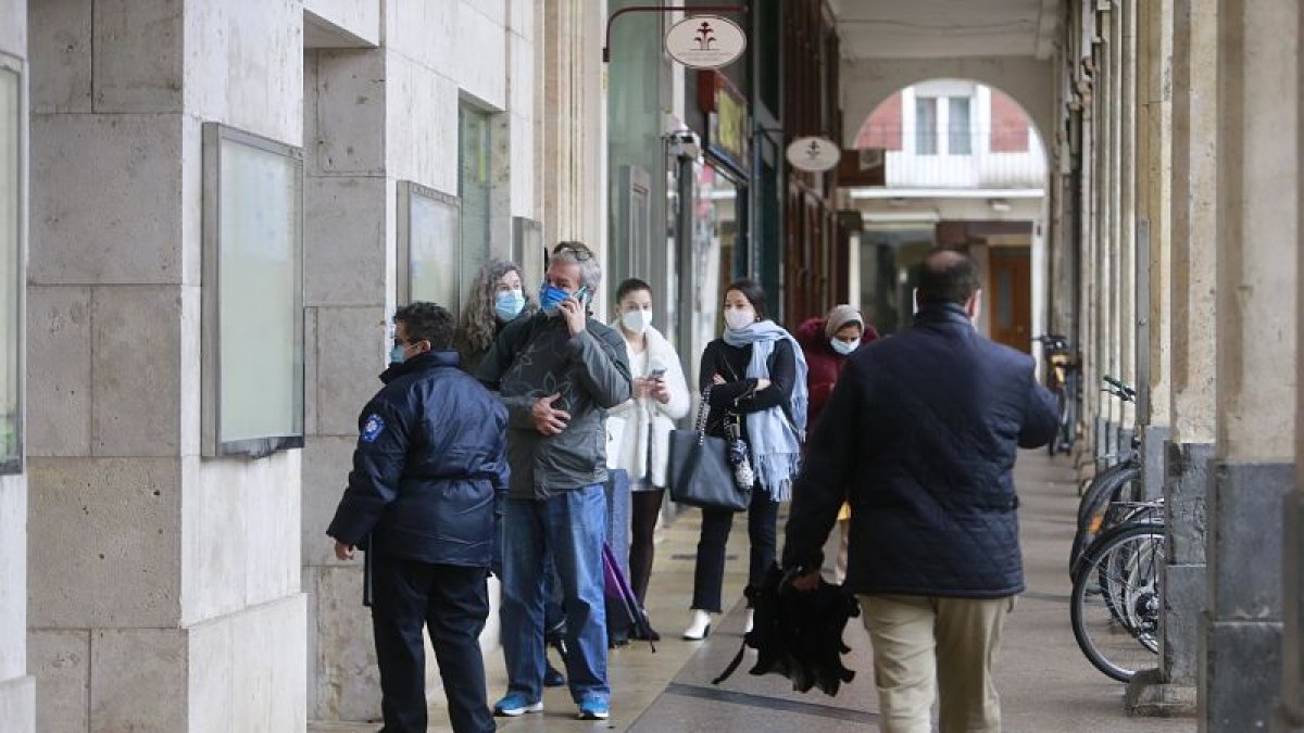 Varias personas haciendo cola a la puerta del Ayuntamiento de Burgos. R. OCHOA