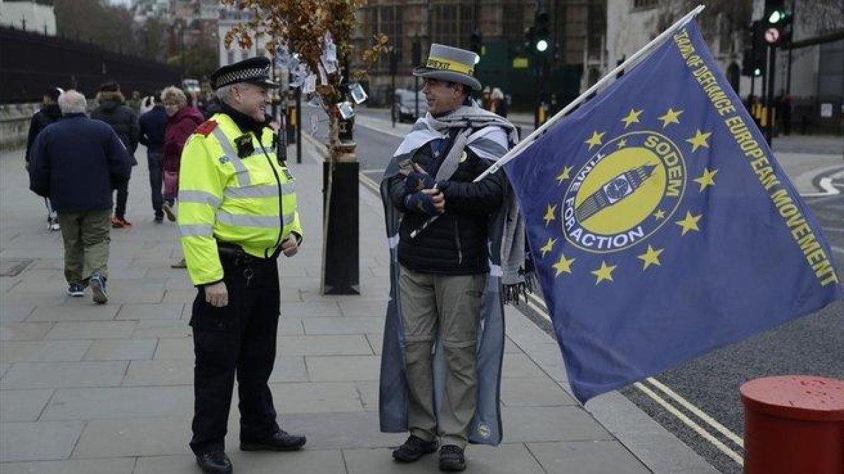Un policía británico habla con un manifestante anti-brexit en Londres.-AP/ MATT DUNHAM