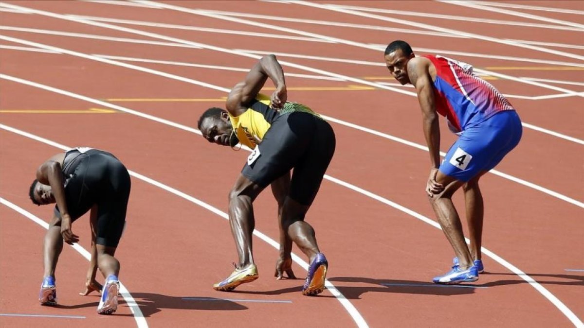 Bolt, a punto de recibir el último testigo del 4x100 jamaicano.-AP / ALASTAIR GRANT