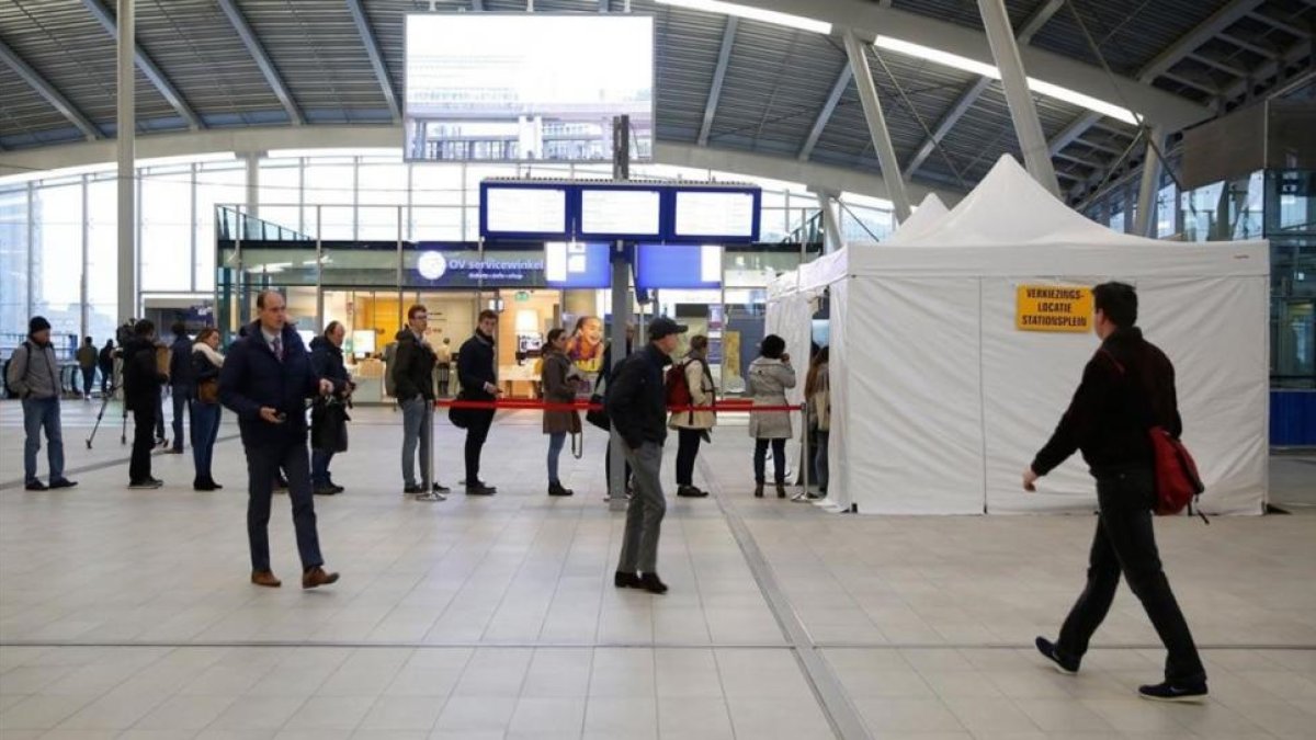 Votantes esperan en la cola para poder votar en la estación central de Utrecht (Holanda), este miércoles.-AFP / ROBIN VAN LONKHUIJSEN