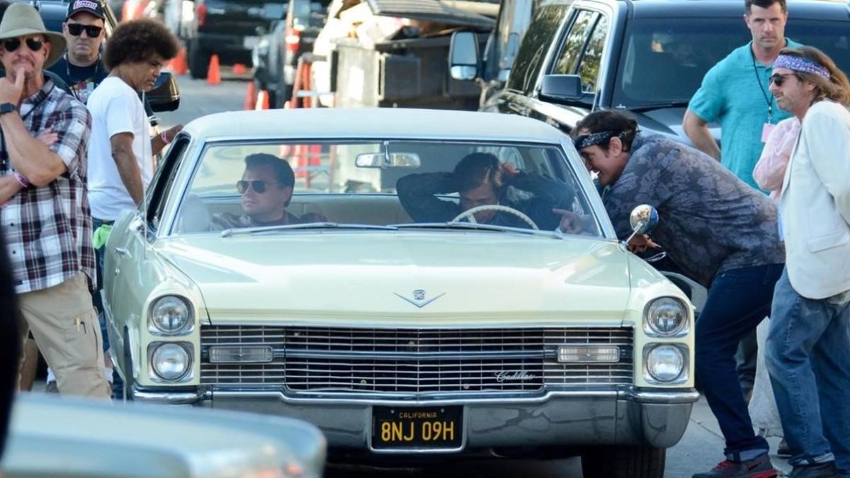 Tarantino se asoma a la ventanilla del conductor para das instrucciones a Brad Pitt (al volante) y Leonardo DiCaprio, en el rodaje de Once upon a time in Hollywood. /-GTRES