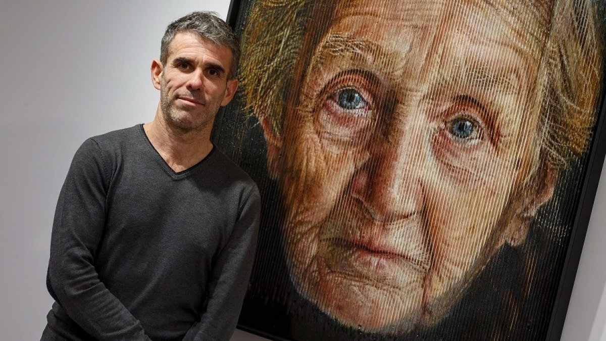 Sergi Cadenas, con su sorprendente cuadro, en la sala de exposiciones de la Fundación Caja Rural. SANTI OTERO
