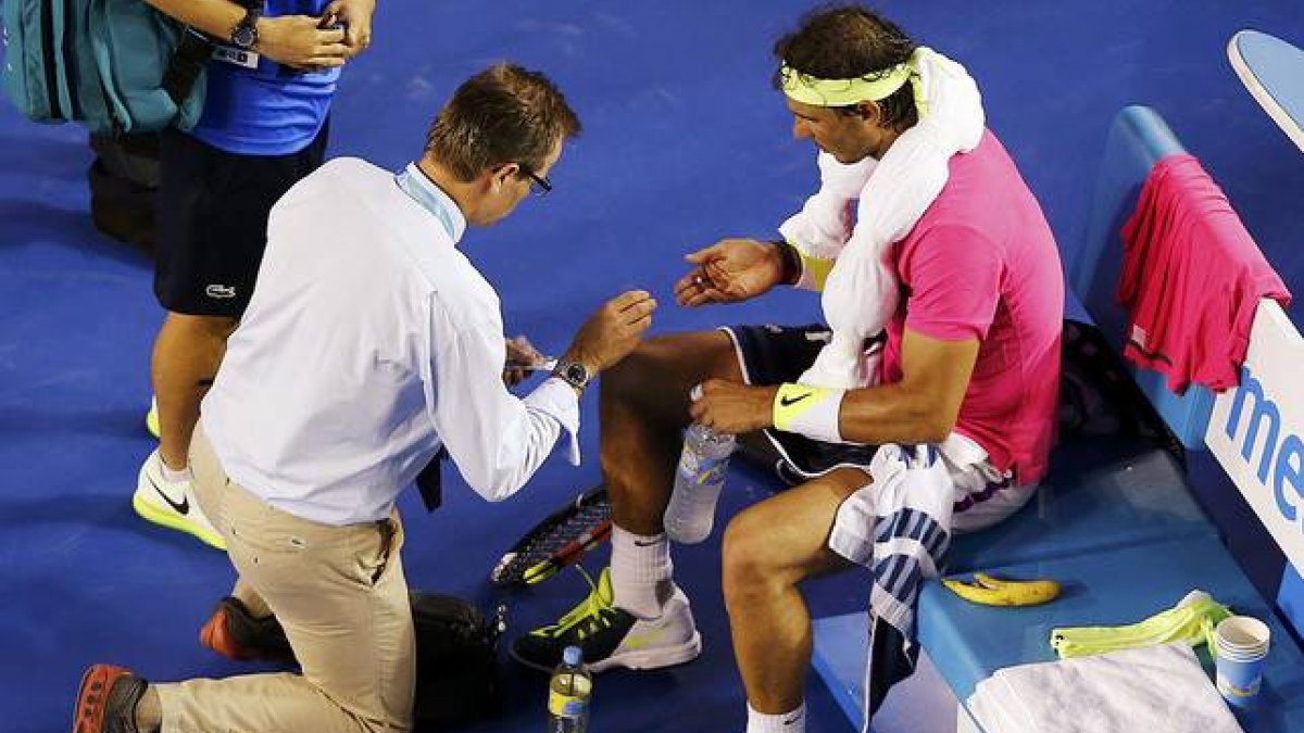 Rafael Nadal es atendido por un médico durante el partido contra Tim Smyczek, durante la segunda ronda del Abierto de Australia.-Foto:   REUTERS / CARLOS BARRIA
