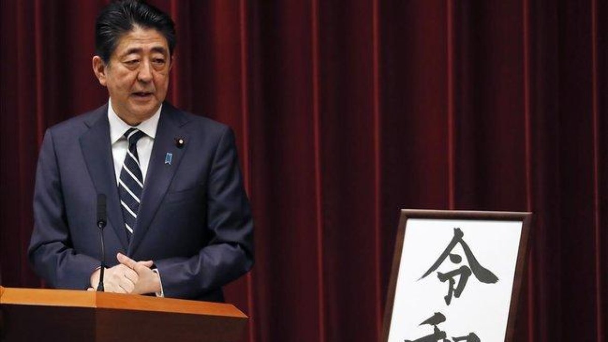 El primer ministro japonés, Shinzo Abe, muestra el nombre de la nueva era del emperador Naruhito.-AP / EUGENE HOSHIKO