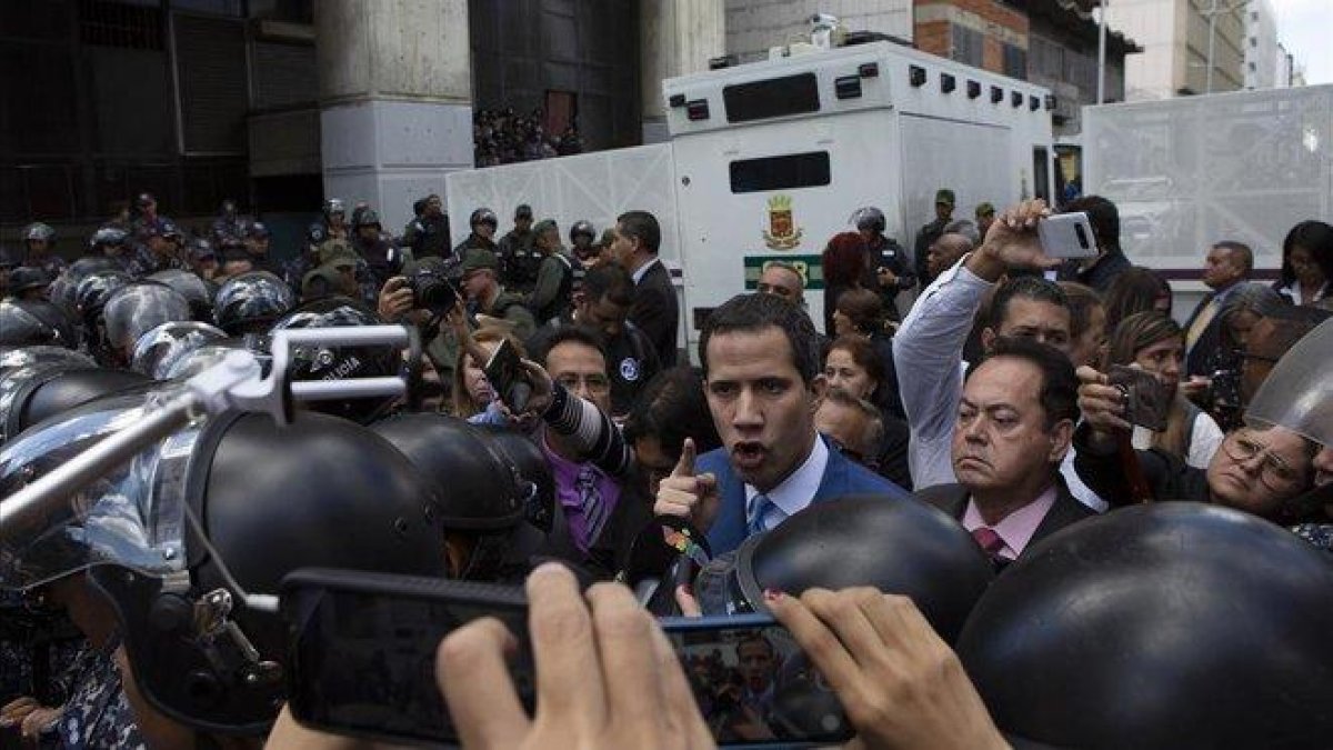 Momento en el que Juan Guaidó es impedido entrar en el edificio del Parlamento venezolano.-AP / ANDREA HERNÁNDEZ BRICE
