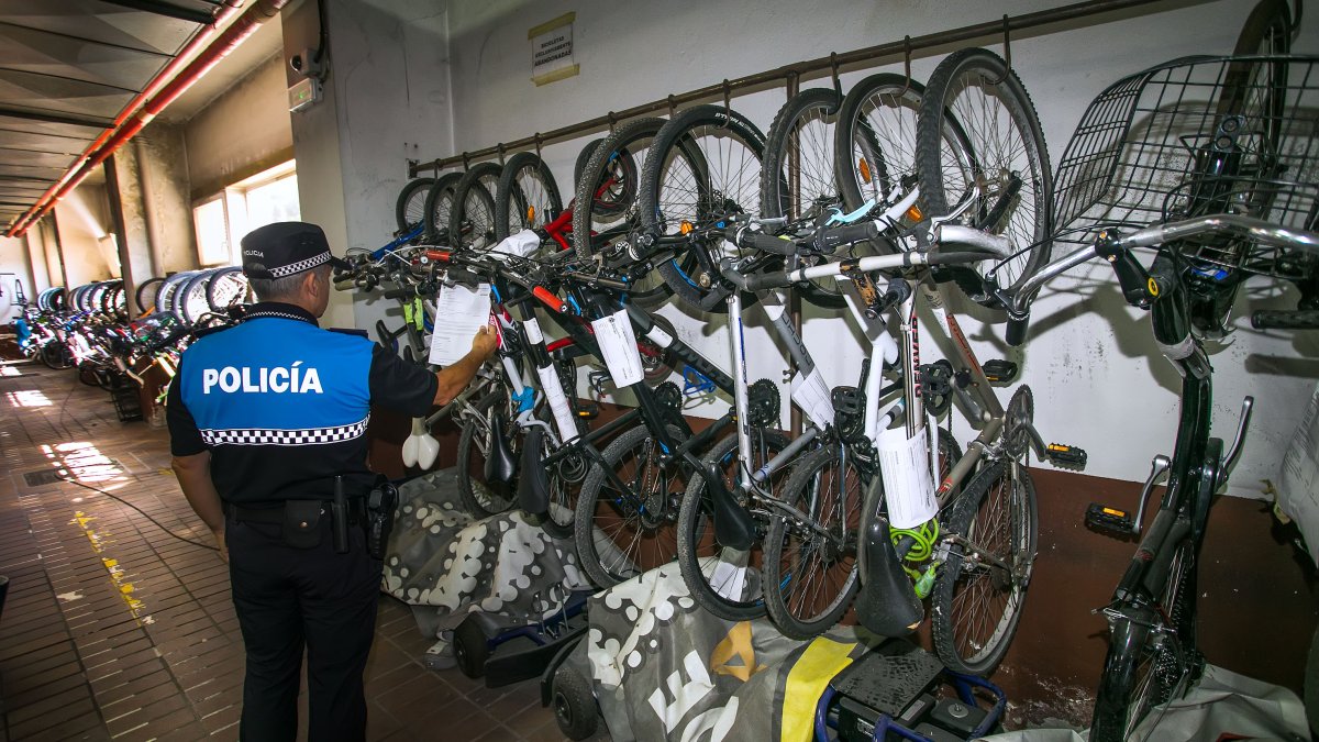 Un agente de Policía Local revisa los detalles de una de las bicis depositadas en la sede de la avenida de Cantabria. TOMÁS ALONSO