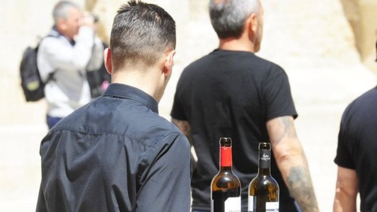 Un camarero sirve una copa de vino en un terraza. ECB