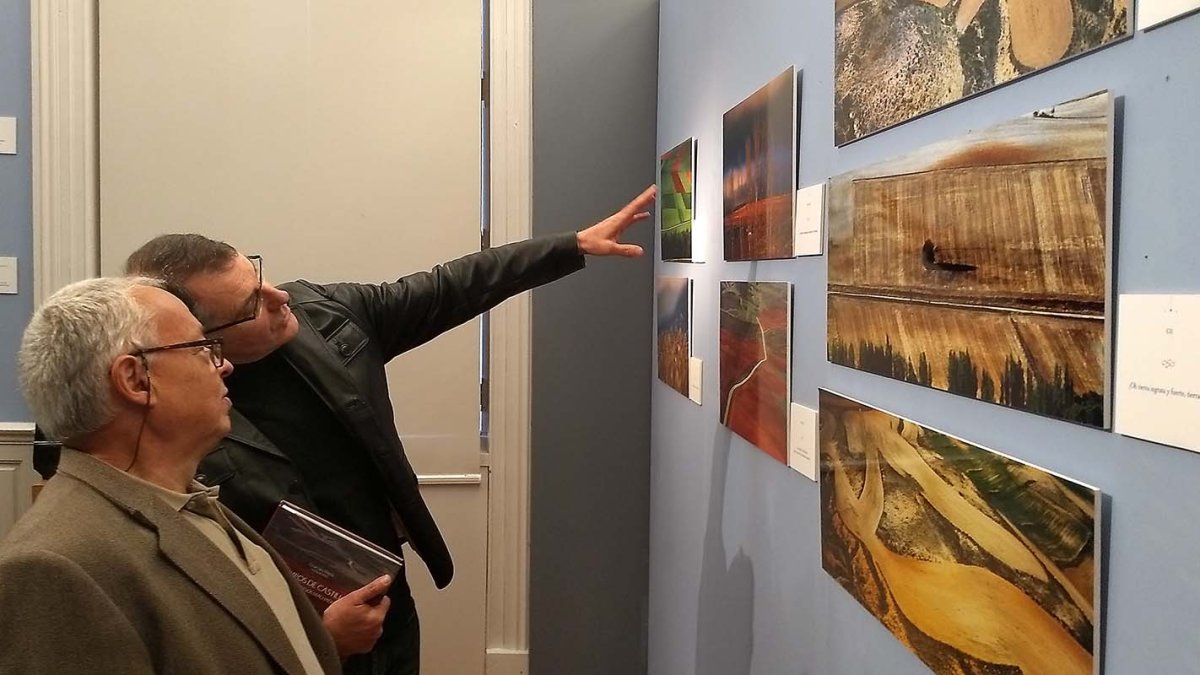 El fotógrafo sorianoCésar Sanz explica a Gonzalo Santonja imágenes de la exposición. ECB