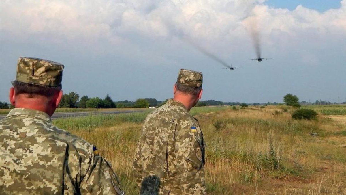 Dos soldados ucranianos contemplan el vuelo de dos Sukhoi rusos.