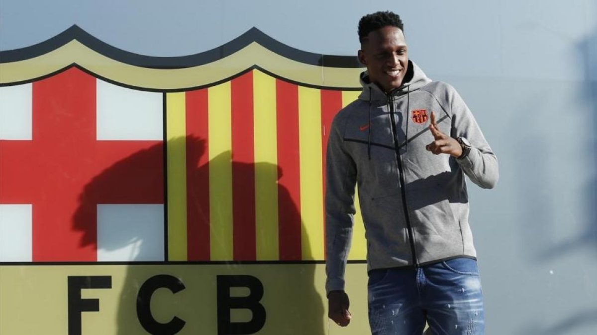 Yerry Mina posa ante el escudo del club.-AFP
