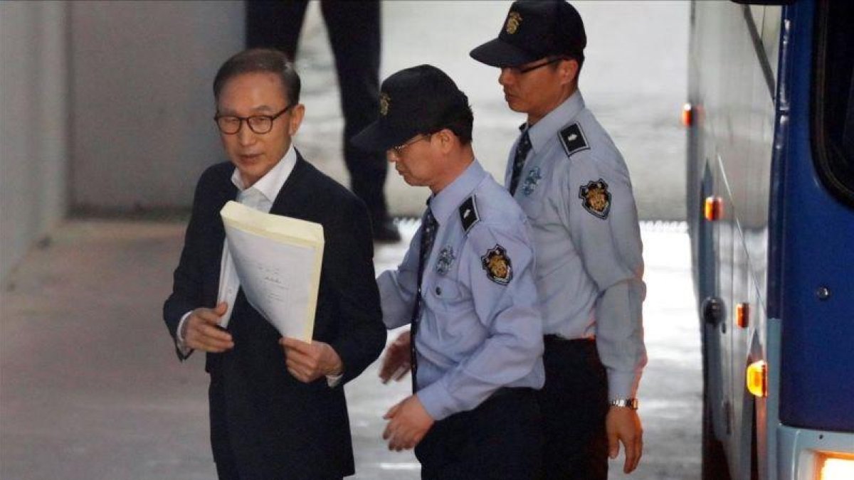 Imagen de archivo del expresidente surcoreano Lee Myung-bak mientras es escoltado por policías en la sala de un tribunal en Seúl.-EFE / JEON HEON-KYUN