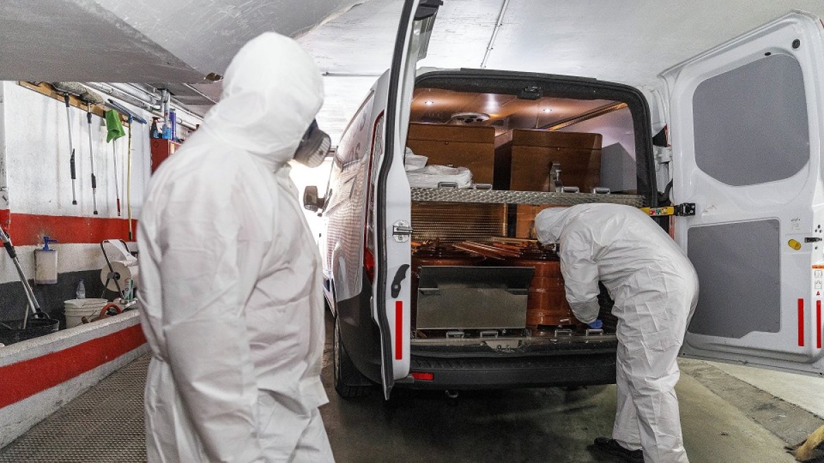 Dos trabajadores de la funeraria Santa Teresa de Segovia, en una imagen de archivo en plena primera ola de la pandemia durante el mes de abril.  ICAL