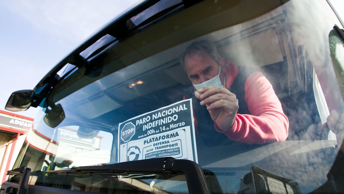 Un transportista cuelga un cartel sobre el paro en el parabrisas de su  vehículo. TOMÁS ALONSO
