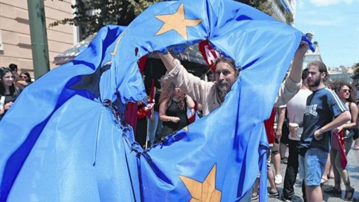 Partidarios del 'no' en el referéndum queman una bendera de la Unión Europea en Grecia durante una protesta en Atenas, ayer.-Foto:  EFE / ARMANDO BABANI