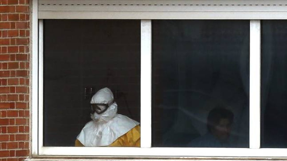 Un sanitario, en una de las habitaciones en las que están aislados los pacientes, en la sexta planta del Hospital Carlos III, el jueves.-Foto: AP