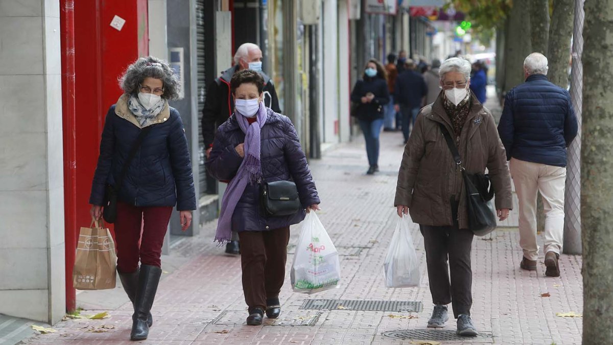 Tres mujeres caminal por Burgos con bolsas de la compra. RAÚL OCHOA