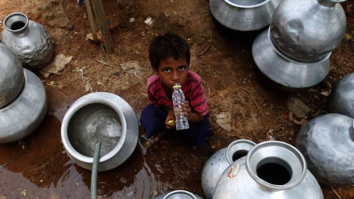Un niño indio recoge agua en un depósito gubernamental en Bhubaneswar, este sábado.-Foto:   AP / BISWARANJAN ROUT