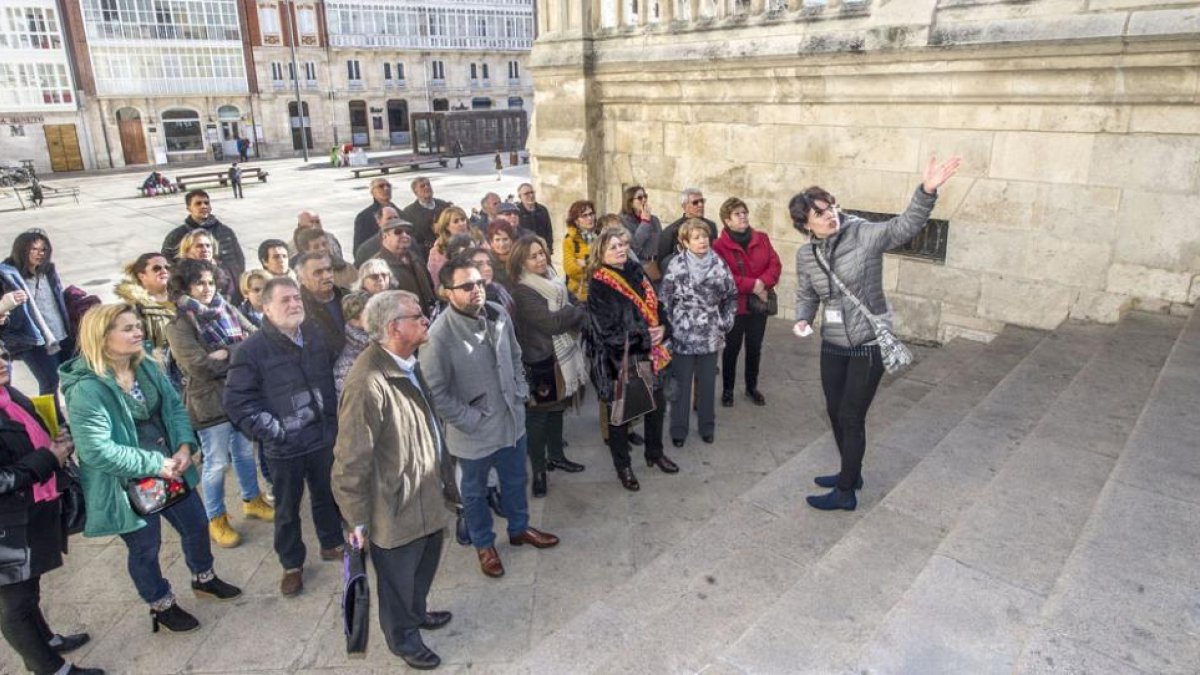 Un grupo de turistas españoles atiende a las explicaciones de su guía al pie de las escaleras de la puerta del Sarmental.-ISRAEL L. MURILLO