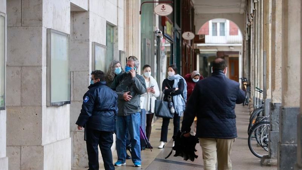 Varias personas haciendo cola a la puerta del Ayuntamiento de Burgos. ECB