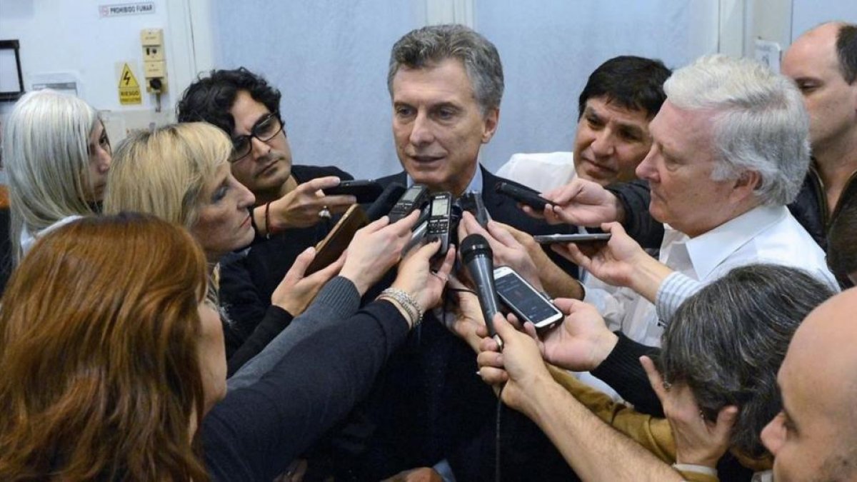 Macri, rodeado de periodistas, en el palacio presidencial, en Buenos Aires, este lunes.-AFP