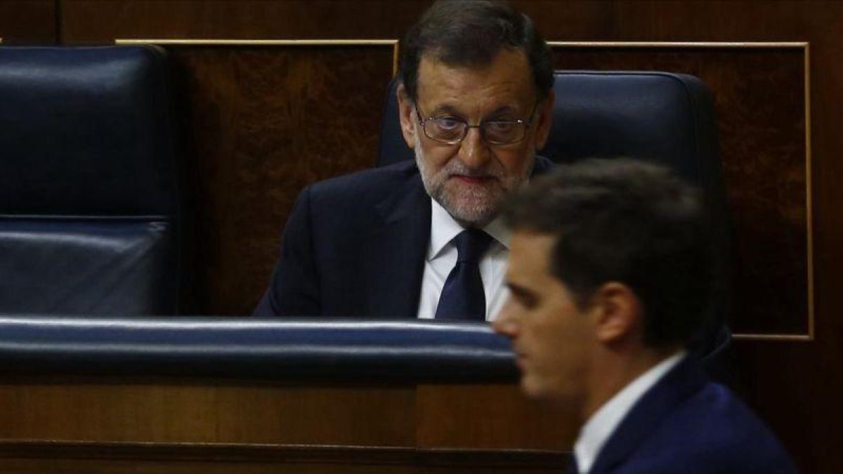 El presidente del Gobierno, Mariano Rajoy, en una sesión parlamentaria observa el paso del líder de Cs, Albert Rivera.-AGUSTIN CATALAN (ARCHIVO)