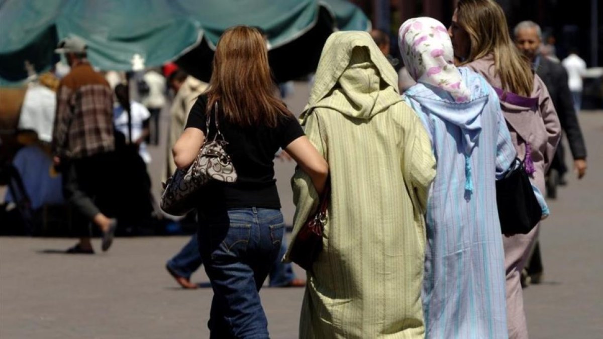 Mujeres vestidas al uso occidental junto a otras con vestimentas tradicionales, en la plaza Jemaa El Fna, en Marraquech, en una imagen de archivo.-/ XAVIER JUBIERRE