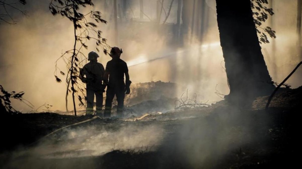 Unos bomberos tratan de controlar el fuego cerca del volcan Vesubio.-CESARE ABBATE