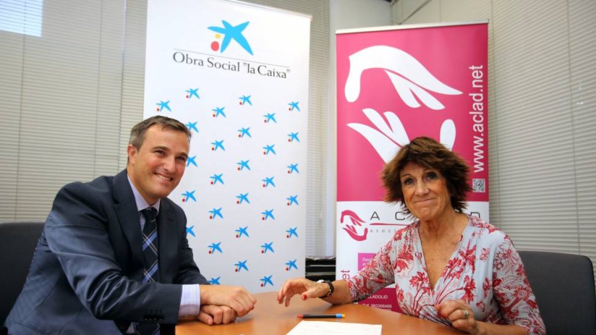 El presidente de la oficina de La Caixa de la calle Embajadores, Juan Manuel Descombes, y la presidenta de Aclad, María Gutiérrez-Cortines, firman la donación de 5.000 euros para la asociación-Ical