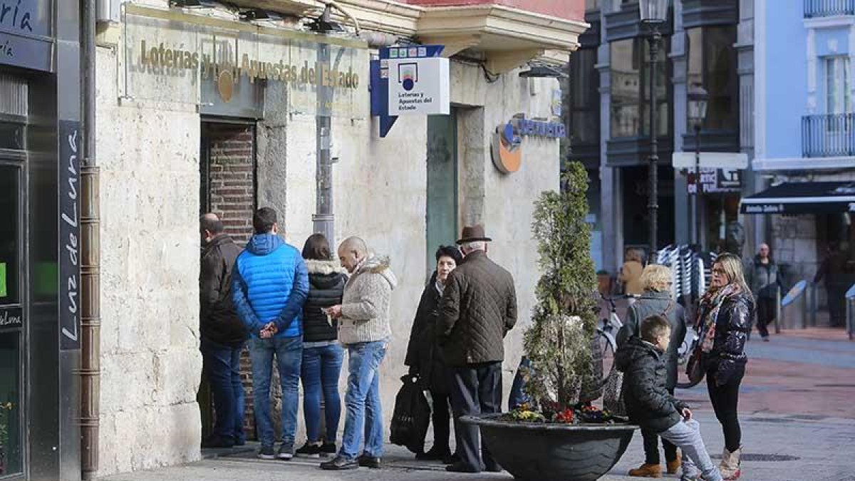 Varias personas hacen cola en la puerta de una administración de loterías de la capital burgalesa.-RAÚL G. OCHOA
