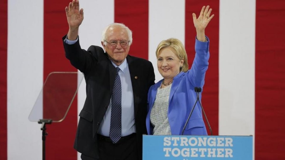 Sanders y Clinton saludan juntos a la audiencia del acto celebrado en Portsmouth (Nuevo Hampshire), este martes.-EFE / CJ GUNTHER