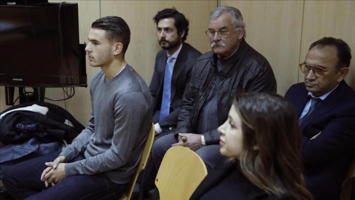 El futbolista Lucas Hernández y su pareja, en una imagen del juicio del pasado día 21 de febrero.-EFE