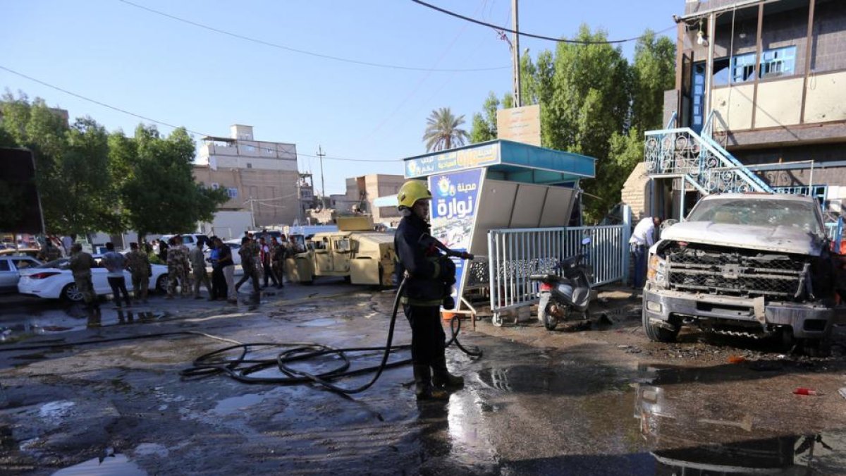 Un bombero apaga los restos del atentado en Kerbala.-REUTERS