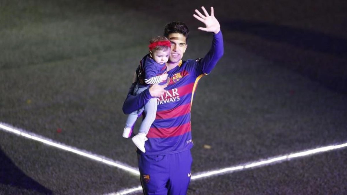 Bartra celebra con su hija Gala la fiesta del doblete del Barça en el Camp Nou.-JULIO CARBO