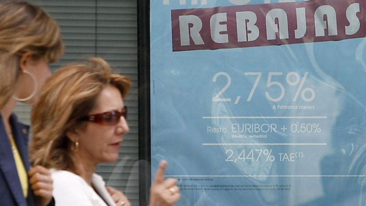 undefinedDos mujeres pasan frente al anuncio sobre hipotecas de una entidad bancaria.