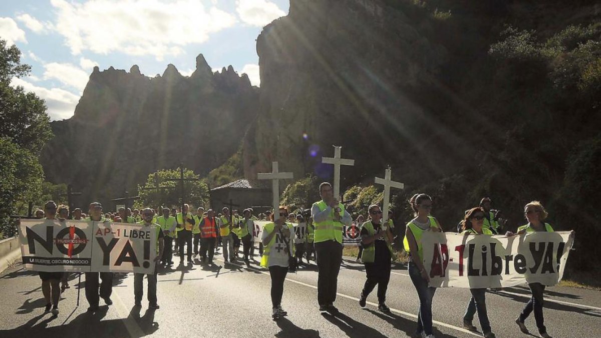Los manifestantes portaron cruces y carteles para exigir la liberalización de la AP-1 y recordar a las víctimas.-GERARDO GONZÁLEZ