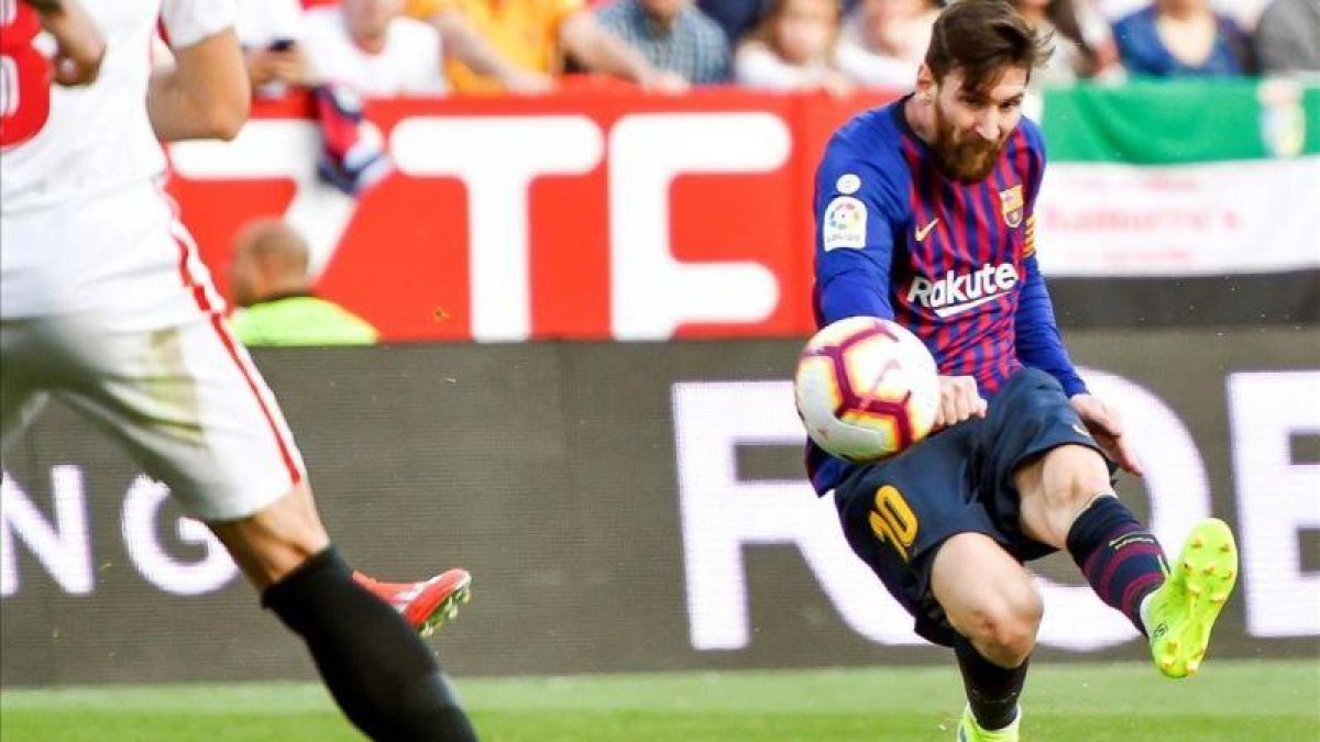Messi dispara a la portería del Sevilla.-RAÚL CARO (EFE)