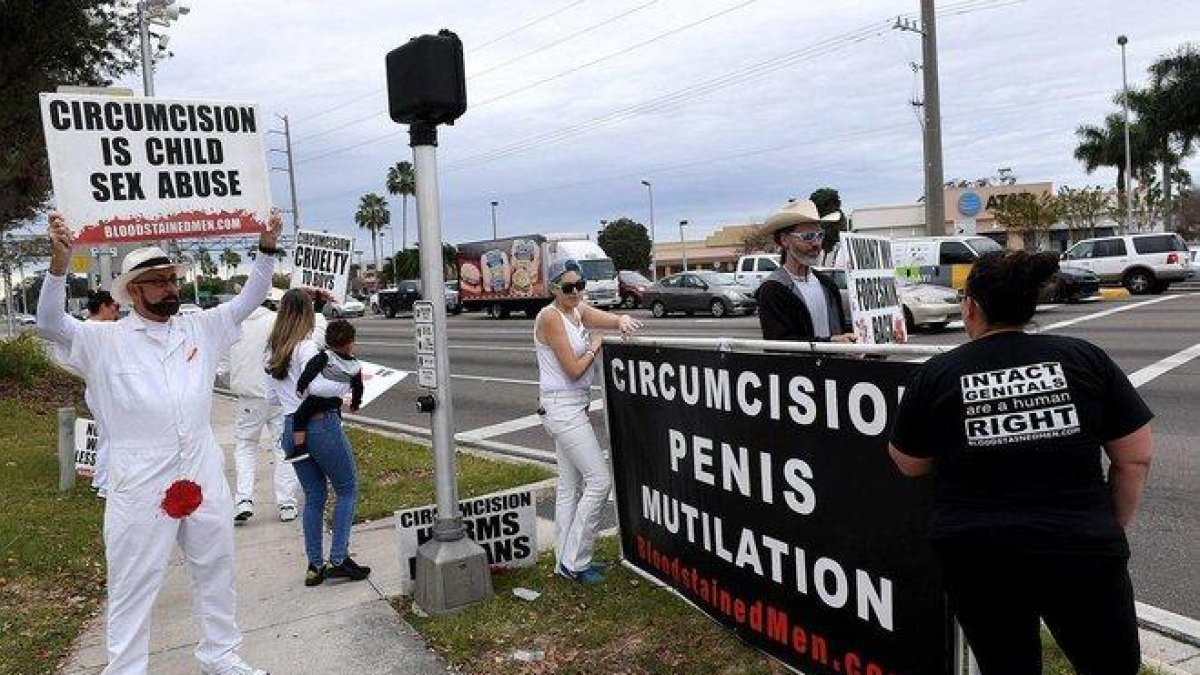 Los activistas portaban letreros que dicen Toca la bocina si amas tu prepucio o los genitales no deberían tener cicatrices.-