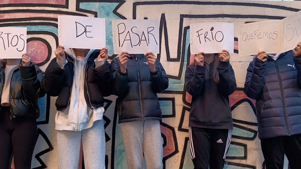 Un grupo de adolescentes posa con unos carteles en los que se lee: «Hartos de pasar frío queremos sitio».