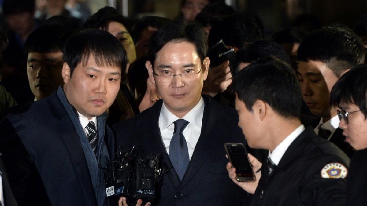 El heredero de Samsung, Lee Jae-Yong (centro), abandona el tribunal que ha ordenado su arresto, este viernes en Seúl.-AFP / YONHAP