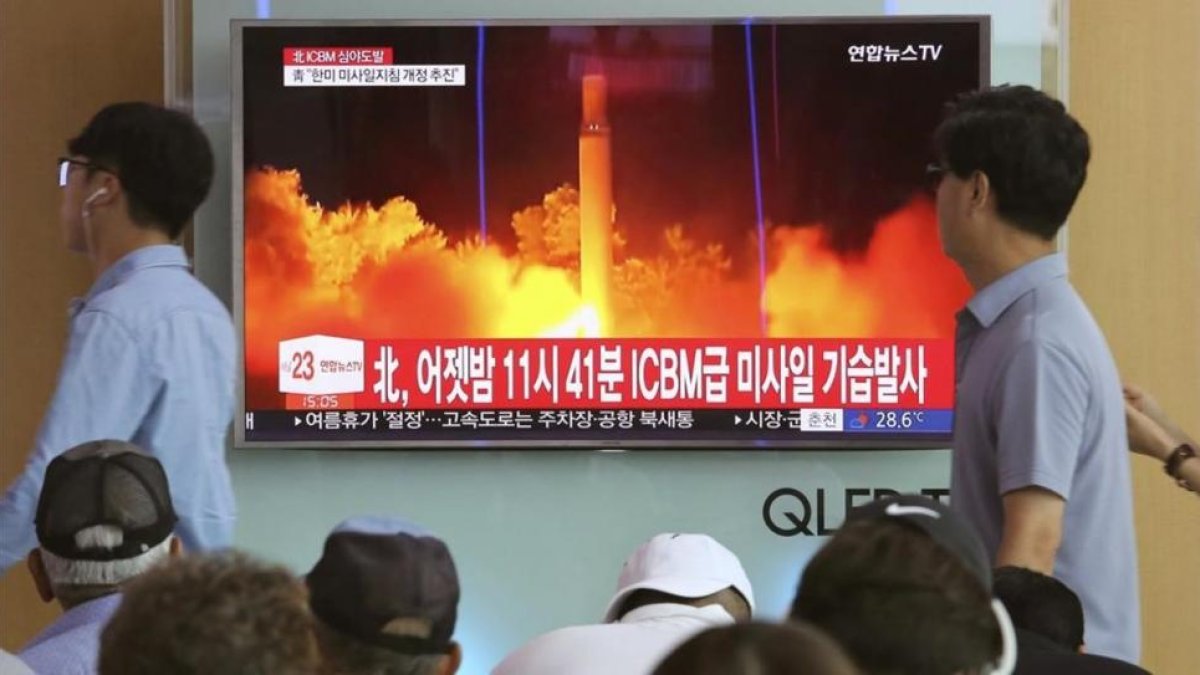 Un hombre pasa en Seúl ante un escaparate con una televisión donde se informa del misil norcoreano.-AHN YOUNG-JOON / AP