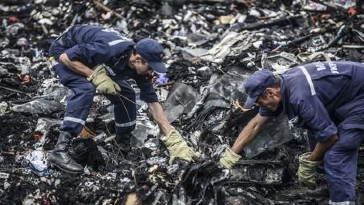 Dos agentes buscan entre los restos del vuelo MH17 de Malaysia Airlines, el pasado 20 de julio en Donetsk (Ucrania).-AFP