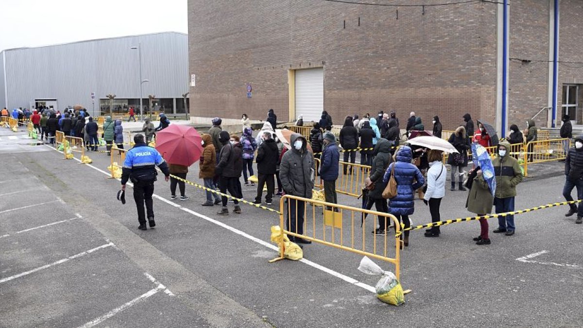 Decenas de personas hacen cola bajo la lluvia para someterse a las pruebas en el polideportivo de Anduva. ICAL