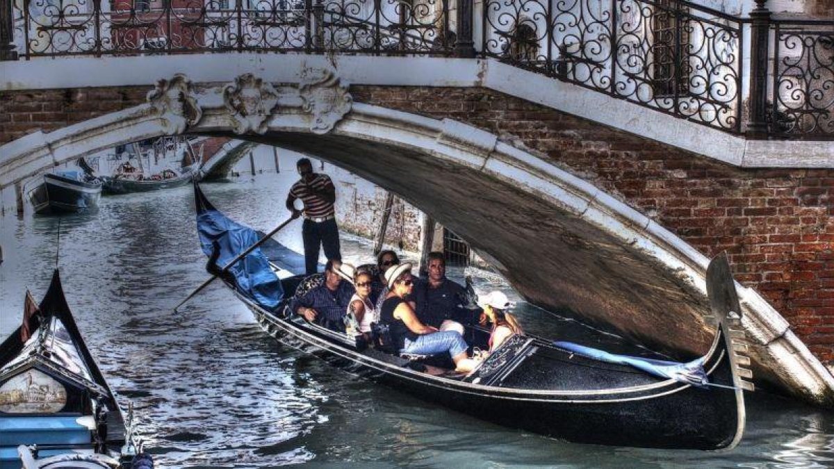 Unos turistas pasean en góndola por Venecia.-JUAN MANUEL PRATS