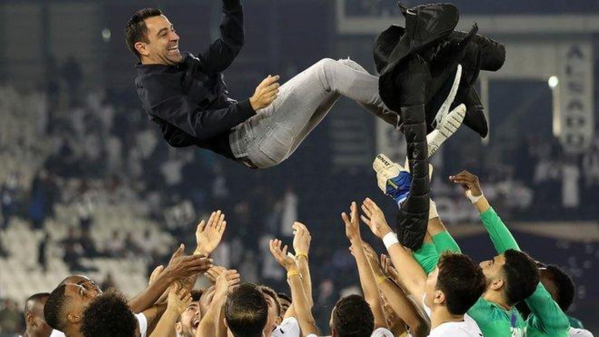 Xavi, manteado por sus jugadores después de ganar la final de la Qatar Cup.-