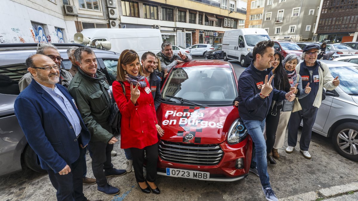 De la Rosa con parte de su candidatura junto al vehículo eléctrico que usa esta campaña electoral.